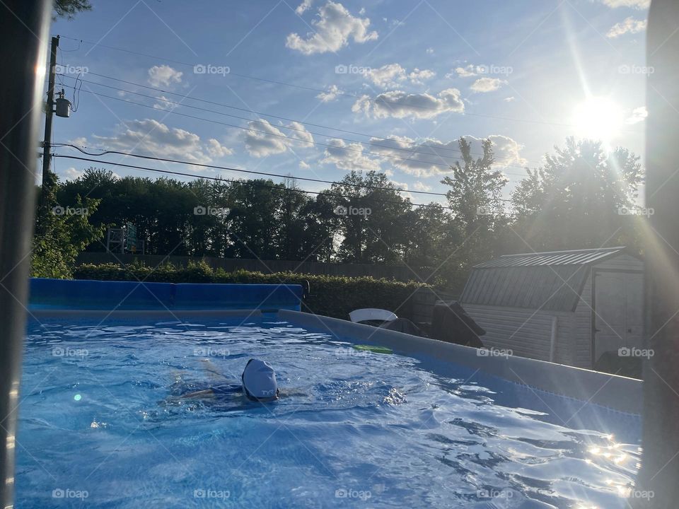 Swimmer on pool in the evening. Beautiful sun view and pool water