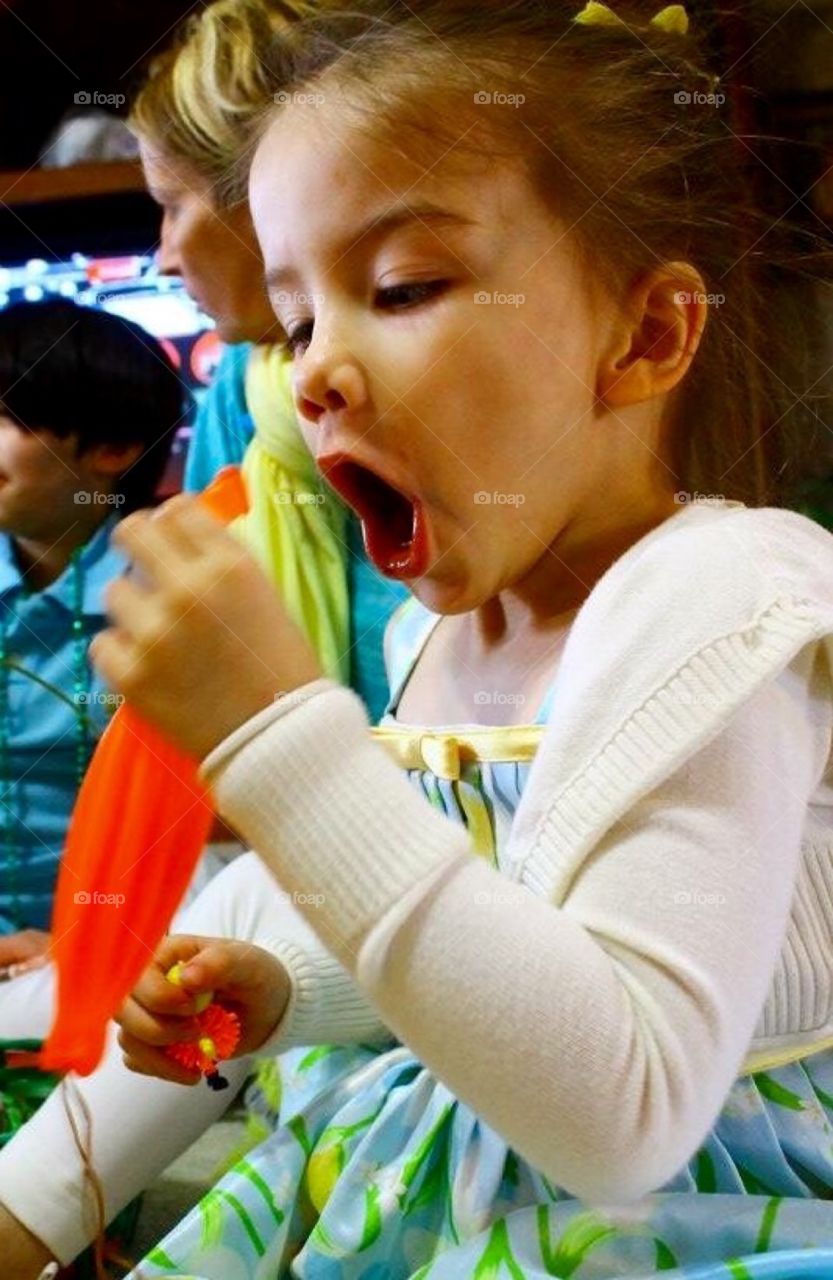 Close-up of a girl holding orange balloon