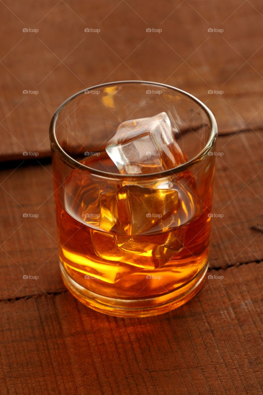 A chilled glass of whisky with ice cubes