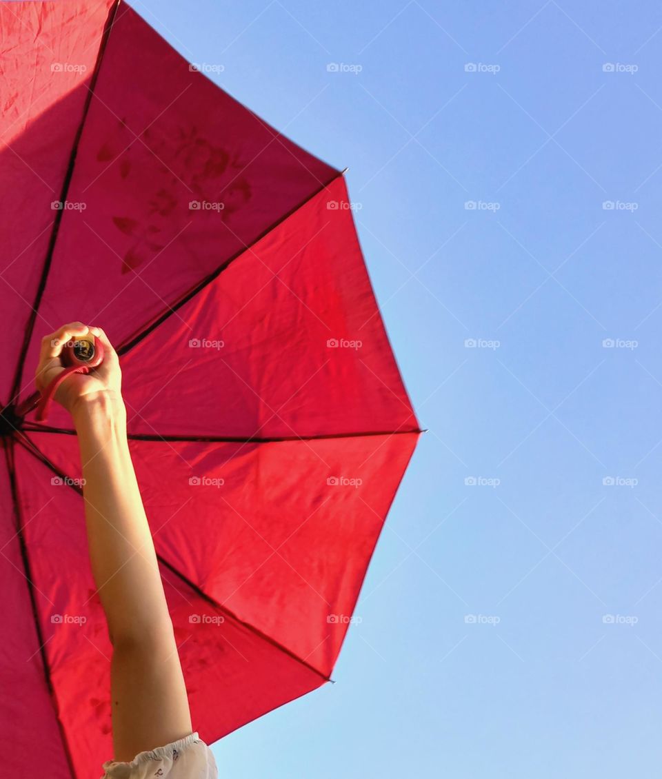girl holding a red umbrella against the blue sky!