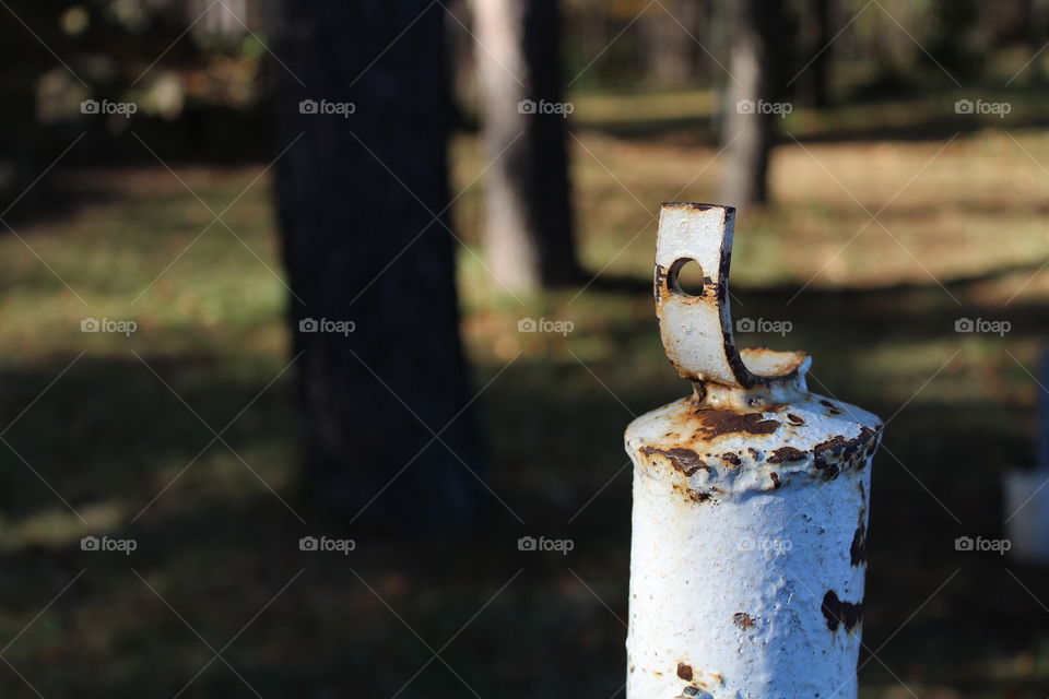 Macro shot of a rusted metallic support with a hole in a forest