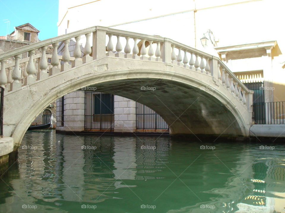 Arched stone bridge over canal in Venice, Italy