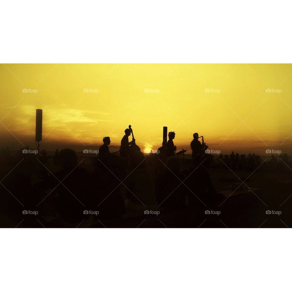 Silhouette of brass band walking down a hill