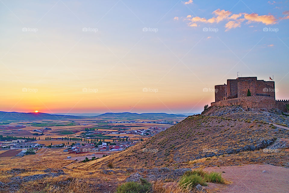 fields and castle of Consuegra, Toledo, Castilla-La Mancha, Spain, during sunset