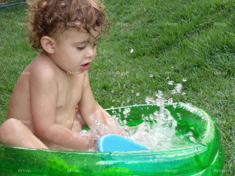 little child playing in the plastic pool