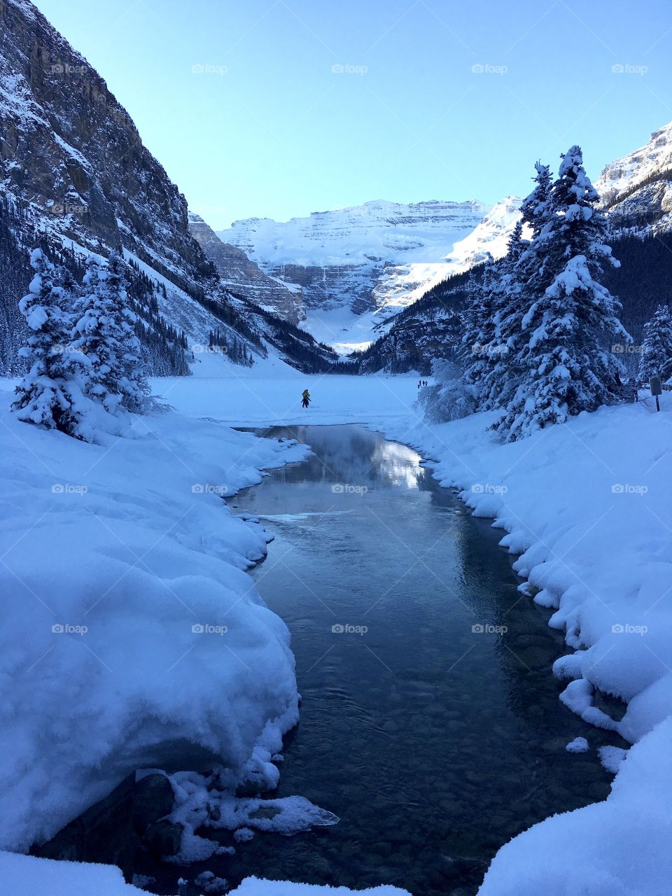 Snow around the stream but the lake is frozen 