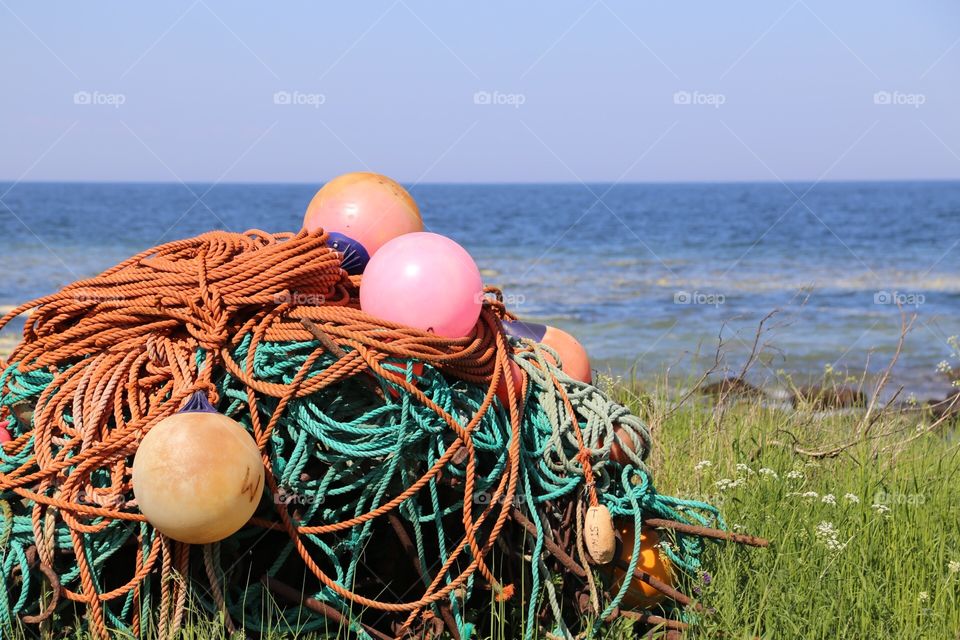 Fishingnet laying on the beach with the blue sea behind