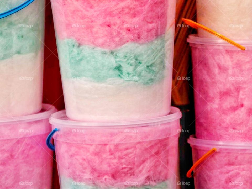 White, green and pink cotton candy in a bucket