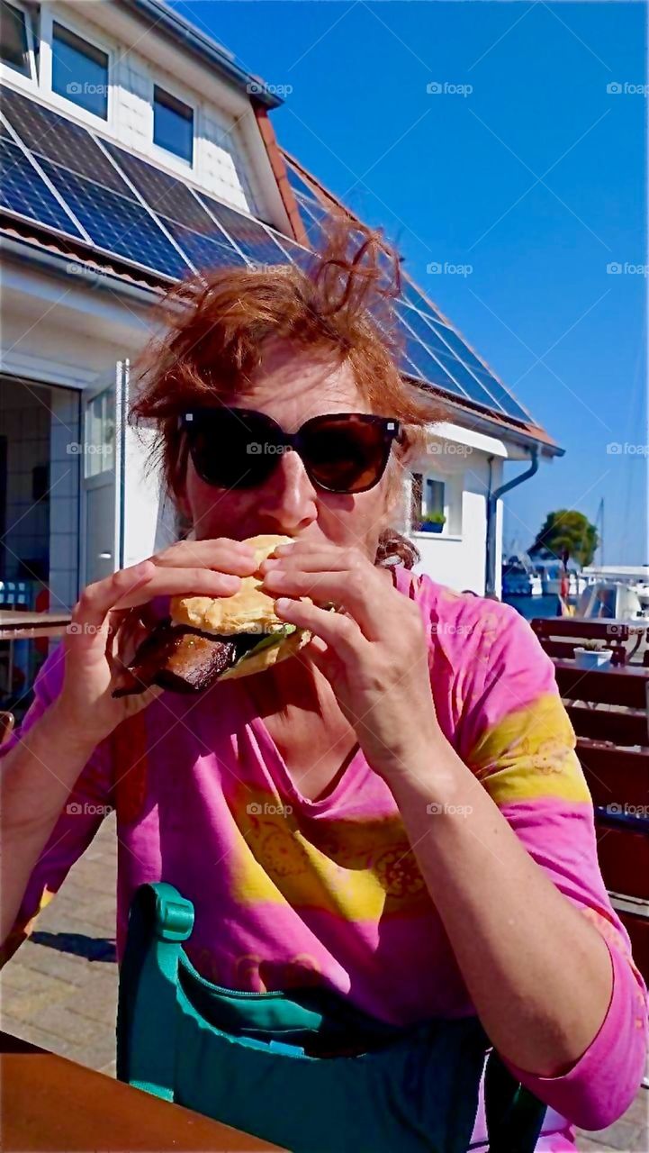 That mackerel sandwich is absolutely delicious here on the beach of the island “Hiddensee” in the “Baltic Sea” or “Ostsee” in “Mecklenburg - Western Pomerania”, Germany and it shows. 2024. Hypnotic Productions
