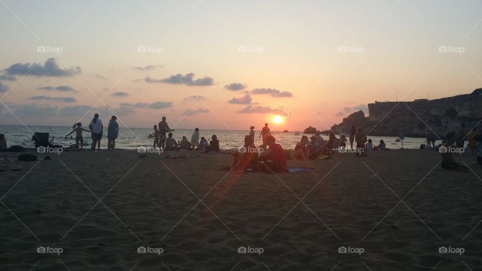 people on a beach at sunset