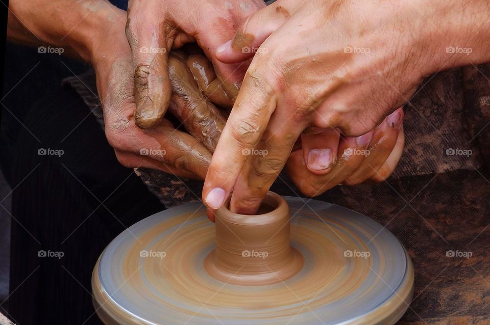 man making pottery out of clay