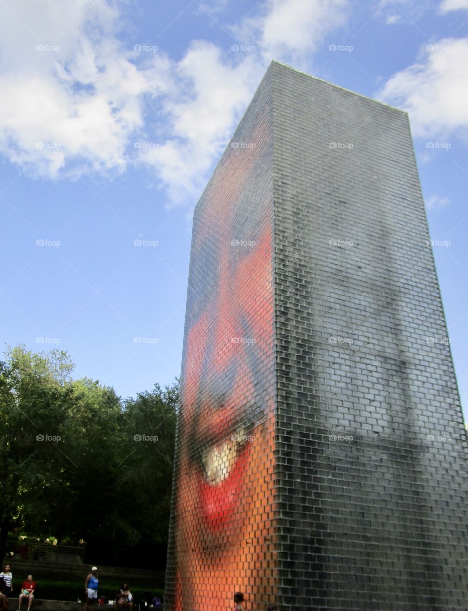 A tall building with one side portraying a huge human face