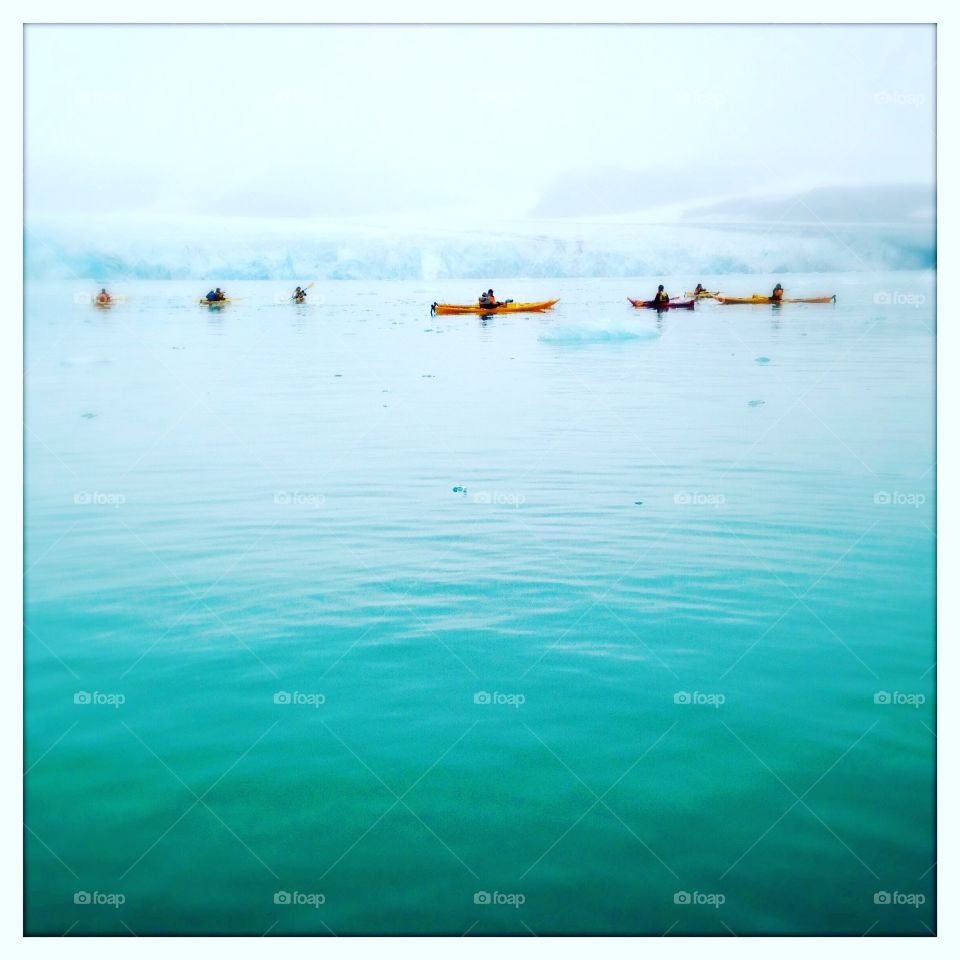 Sea kayakers paddle along an ice edge in Svalbard, Norway.