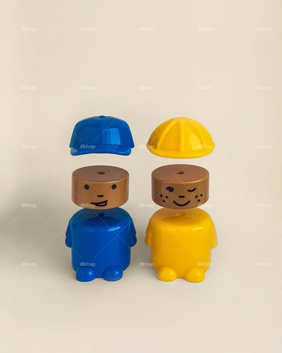 Two toys on beige background, blue toy, yellow toy, levitation 