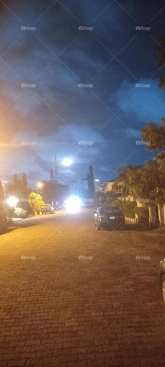 Full moon, street lights creating illusion of many moons. Brilliant light explosion on ground