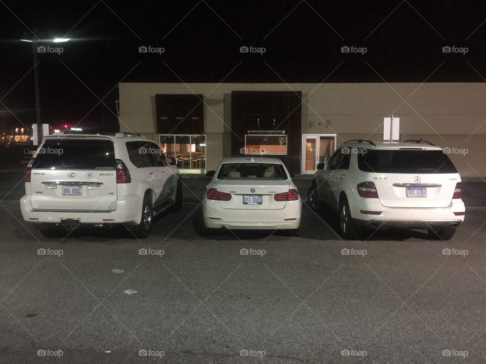 Three White luxury cars at night 