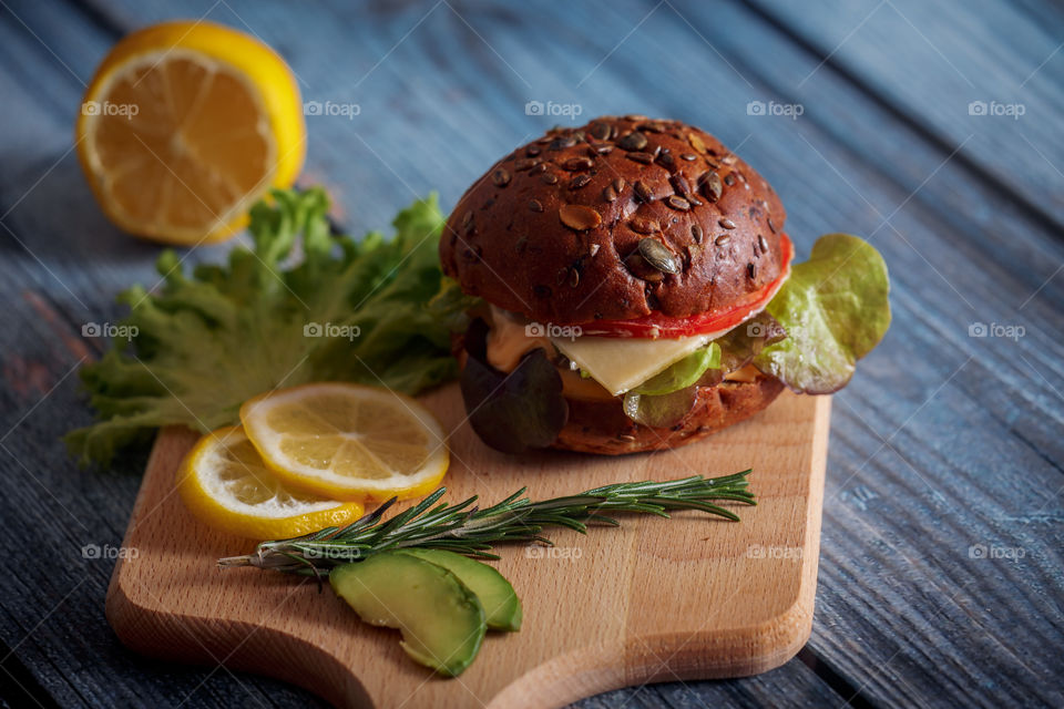 Dark burger with grain bread, cream cheese and avocado