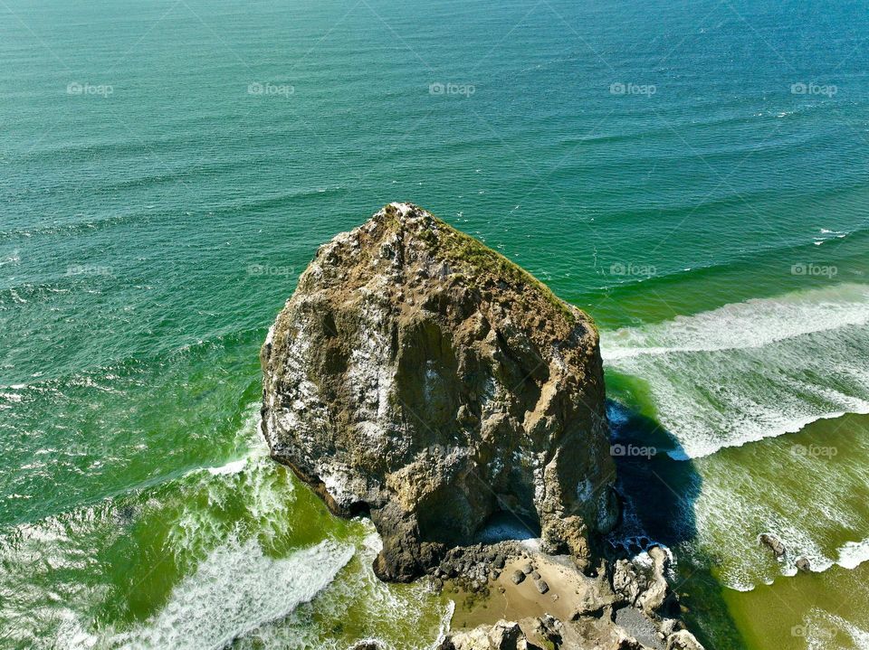 Haystack Rock standing tall amidst the serene beauty of Cannon Beach, where tide pools meet the endless horizon