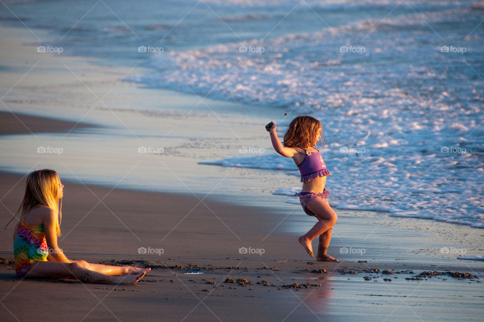 Two young girls playing in the sand on the California beach