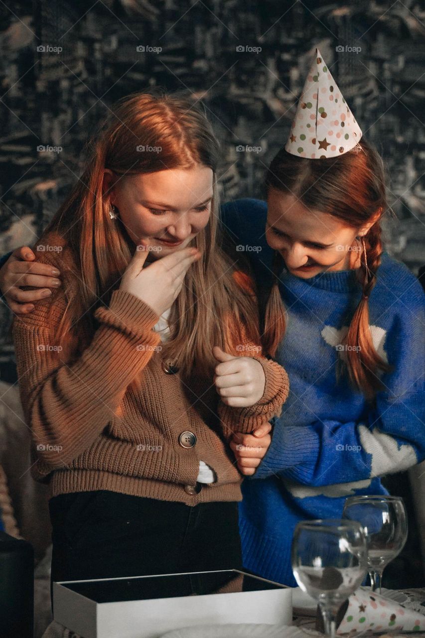 Surprised teenager girl celebrating birthday surprised by cool presents