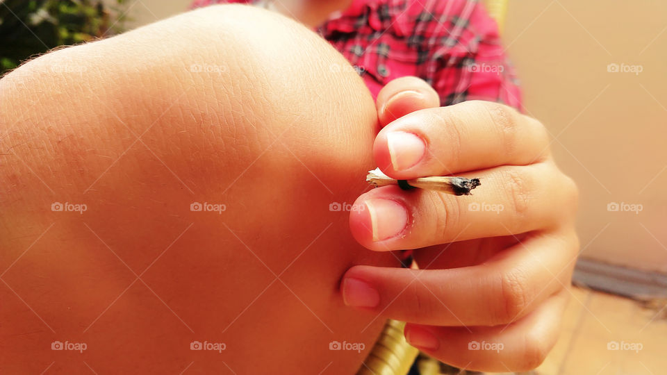 Mão de mulher segurando um cigarro de palha.