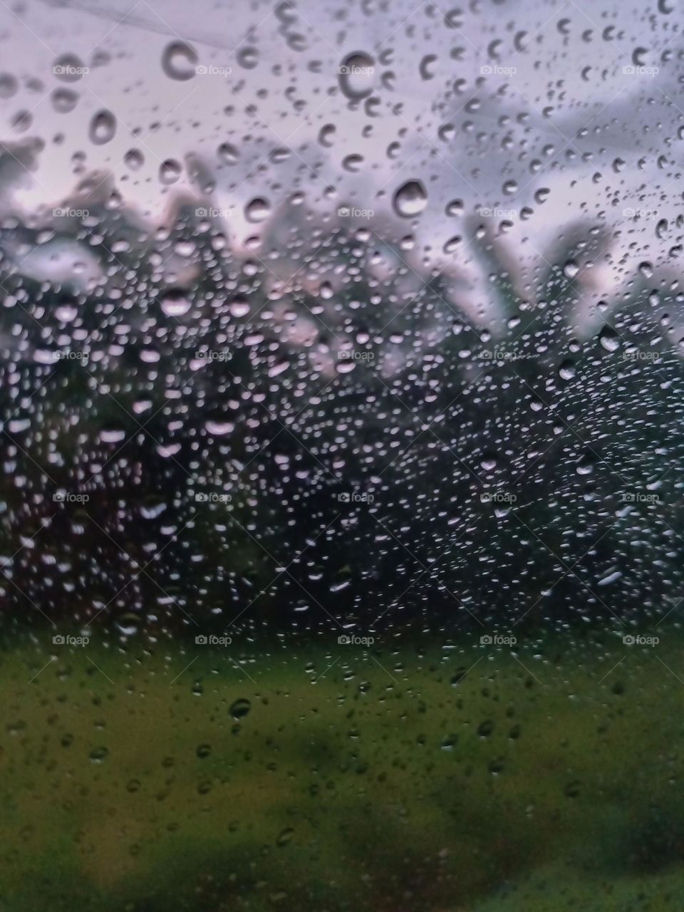 Selective focus on the rain drops on the windshield of the car. After rain at the rainy season