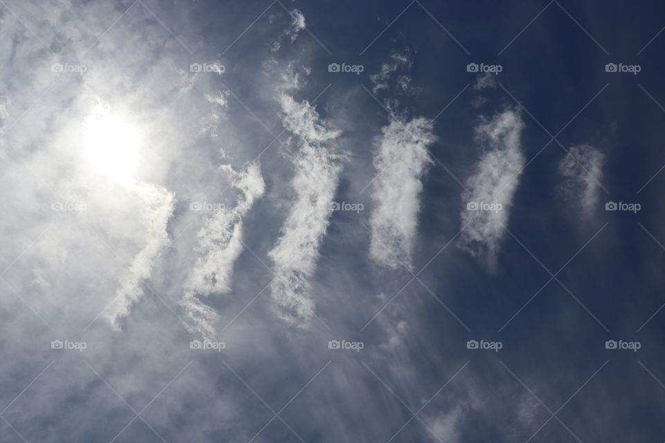A line of clouds within the sky featuring the sun