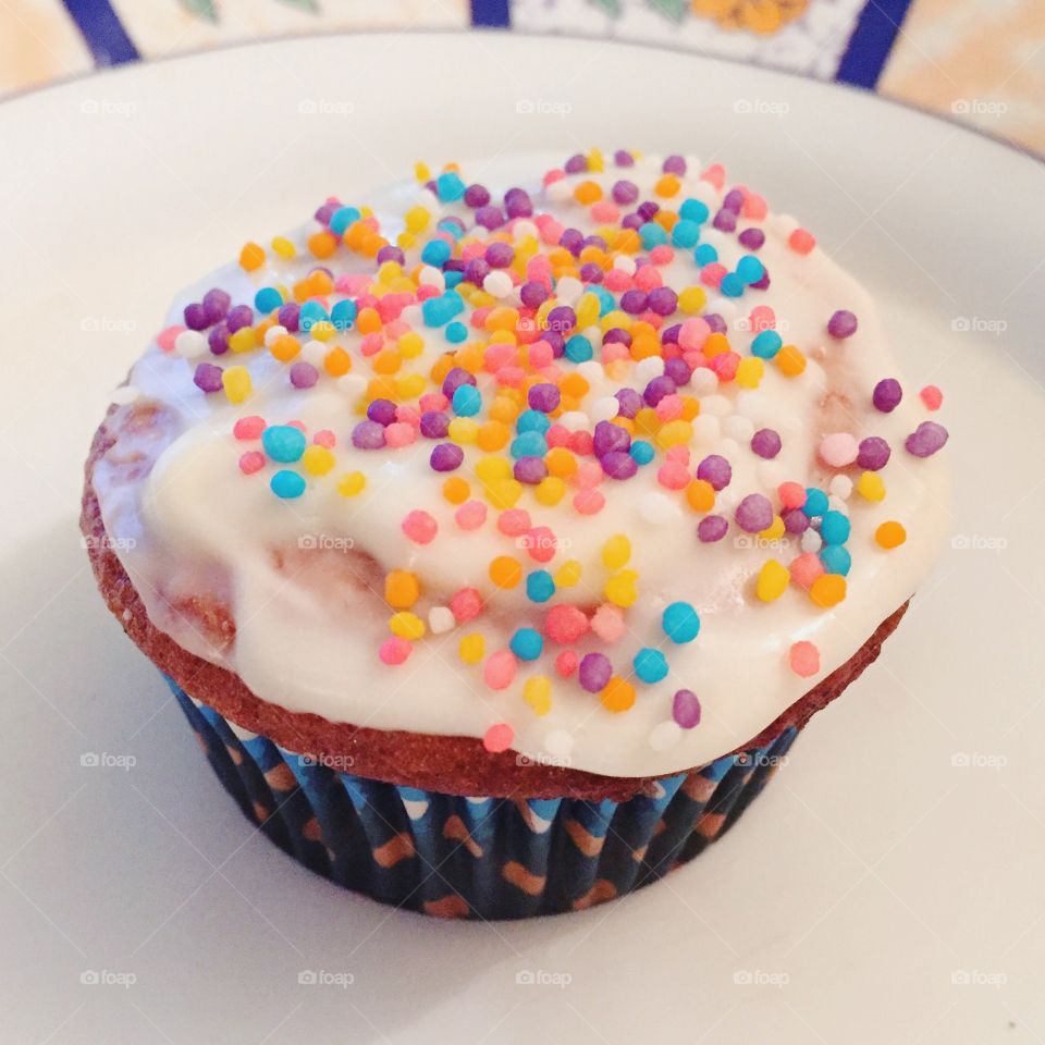 A homemade cupcake with colorful sprinkles on top