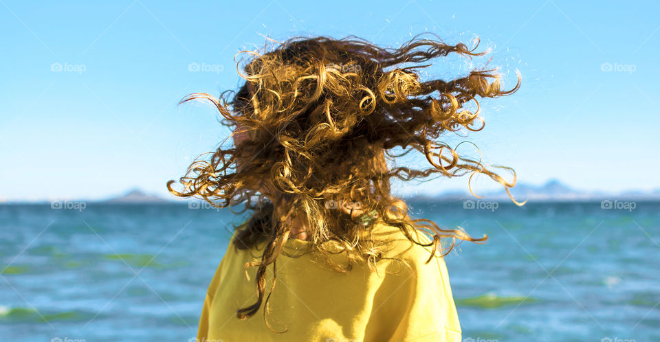 Blonde woman shaking her head at the beach