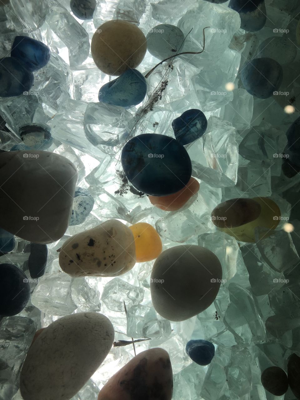 Colourful small crystal stones with light coming across close up 