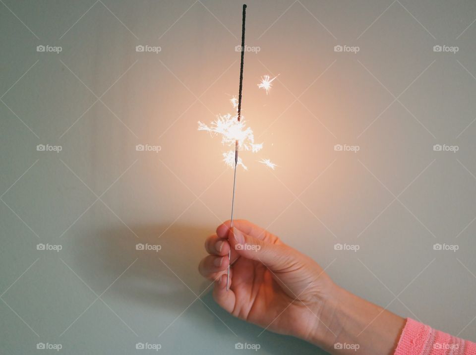 Woman's hand holding burning sparkle