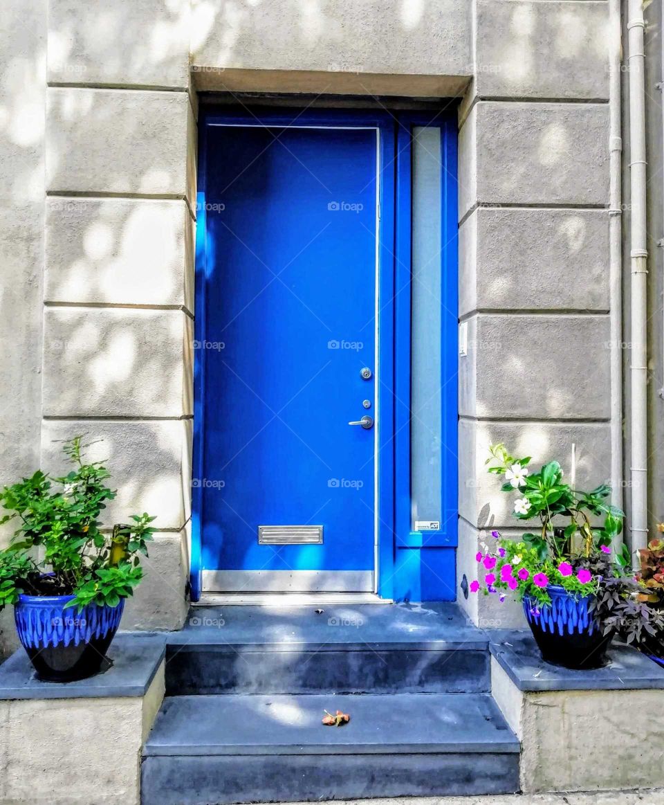 Beautiful and colorful entrance door with a black/blue vase on each side