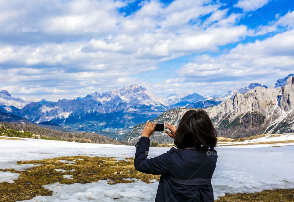 Rear view of woman capturing mountain during winter