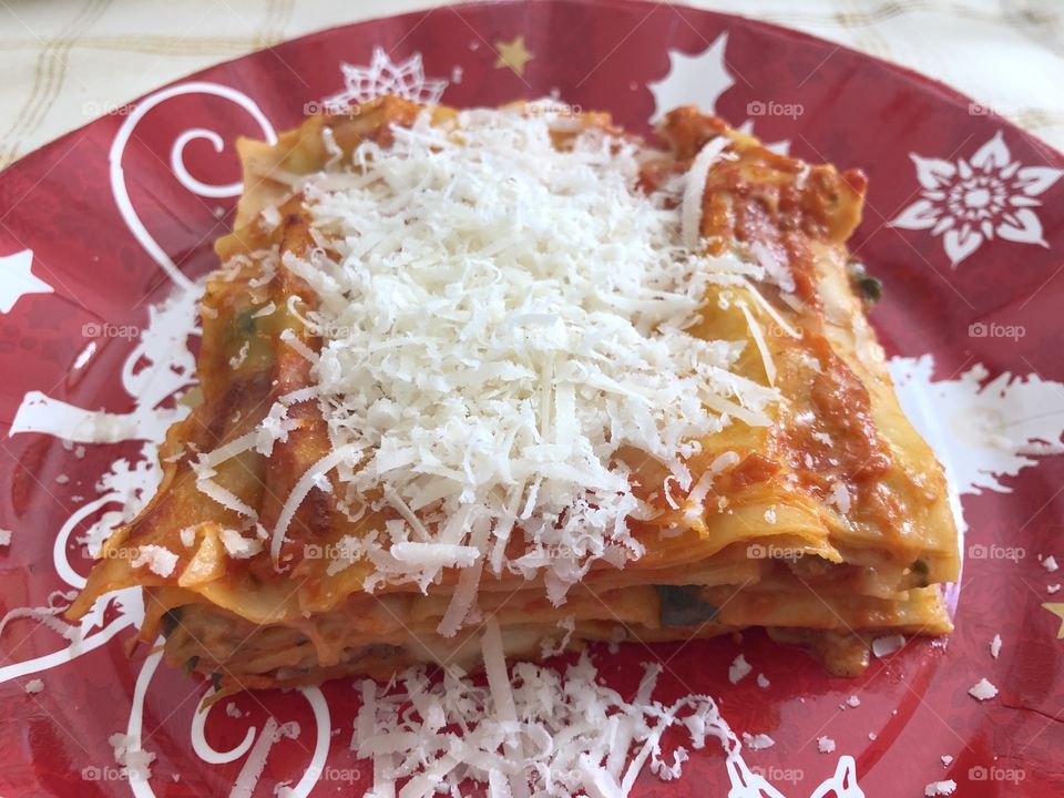 Christmas meal in Italy, a dish of lasagne with much grated cheese