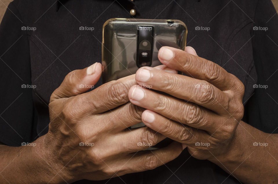 Hands Of Senior Woman Holding A Black Mobile Phone