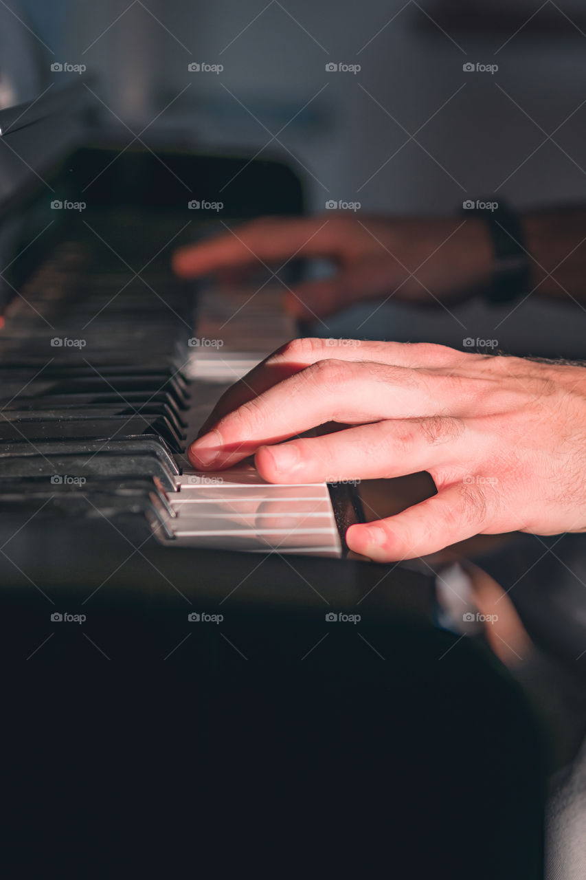 Hands playing a piano