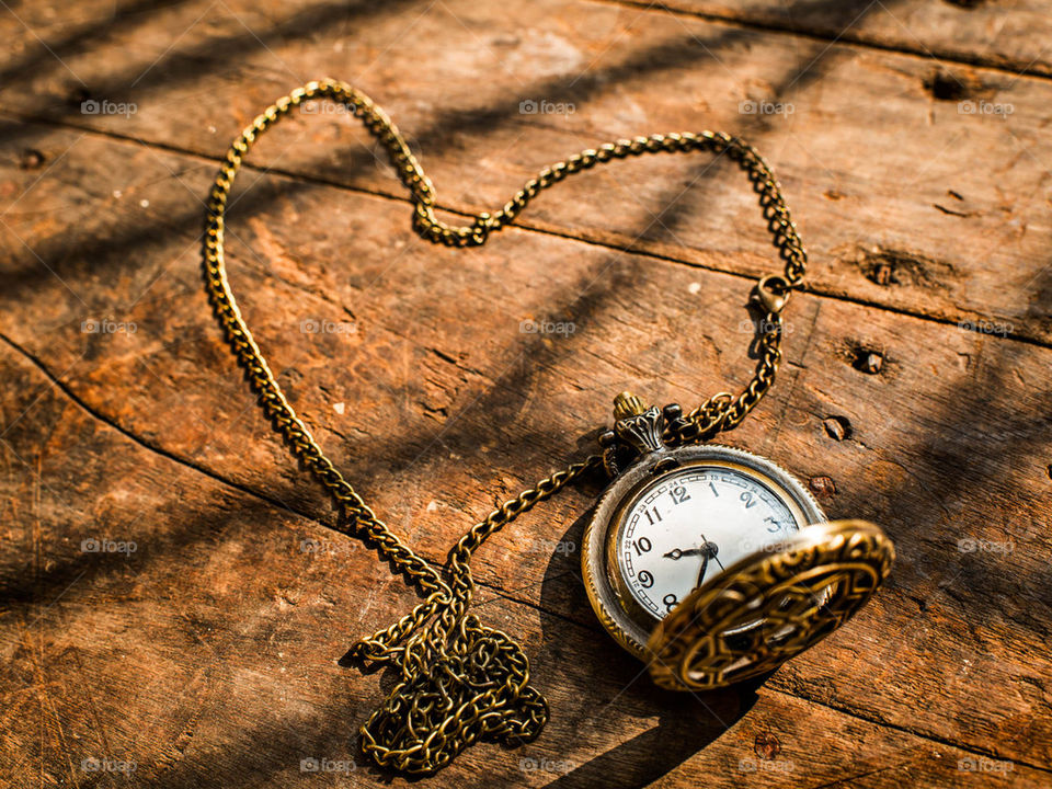 Heart pocket watch on wooden background