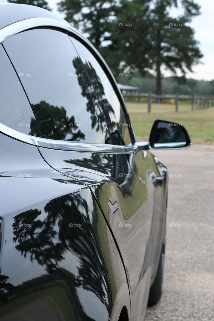 Sleek lines, sporty design, smooth finish. Vehicle reflections in the countryside.