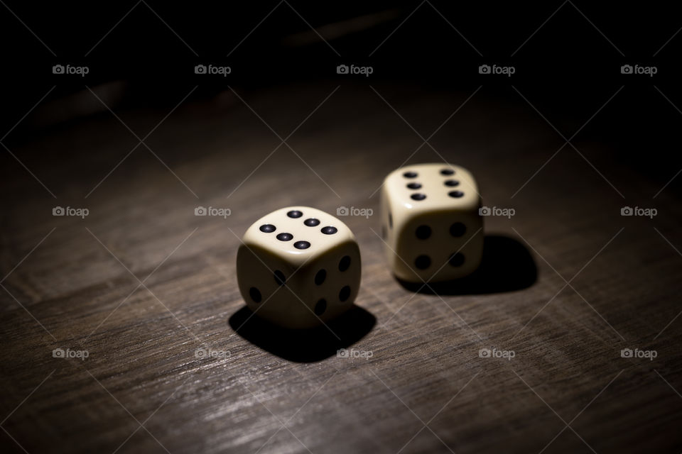 A portrait of a set of two dices. the pair of dice are both showing the six dots on top making a roll of twelve and at the sides show four and two dots.
