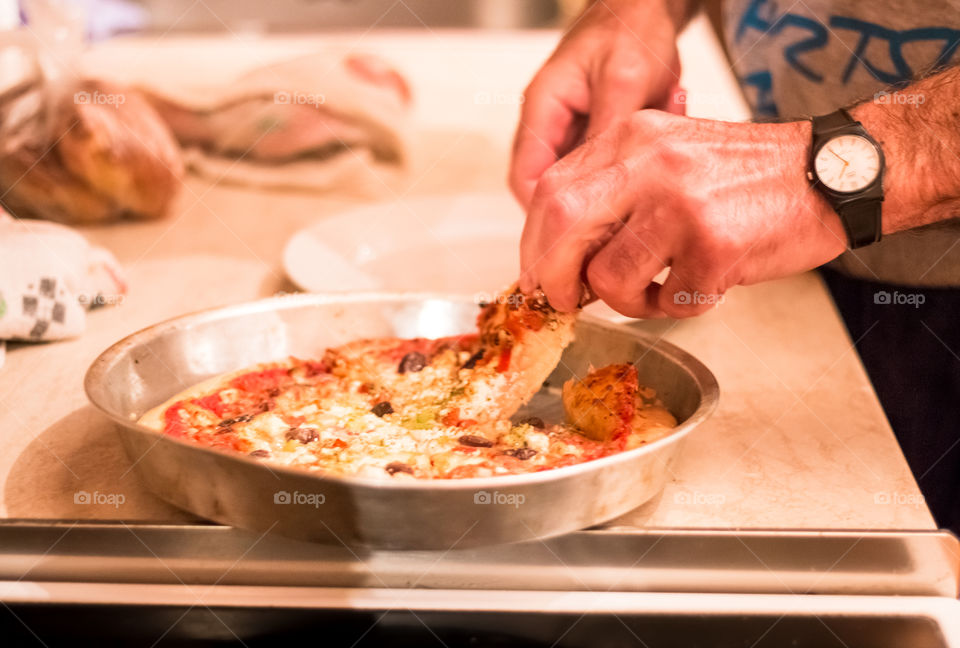 Man Cutting Pizza At Home
