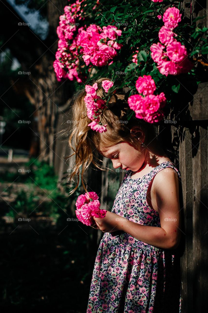 Little beautiful girl with a roses.