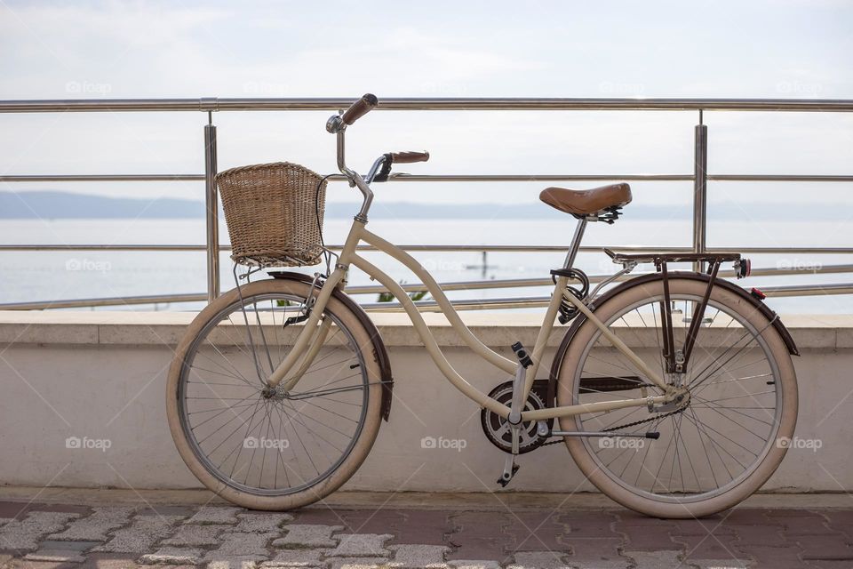 White bicycle with basket on the beach background 