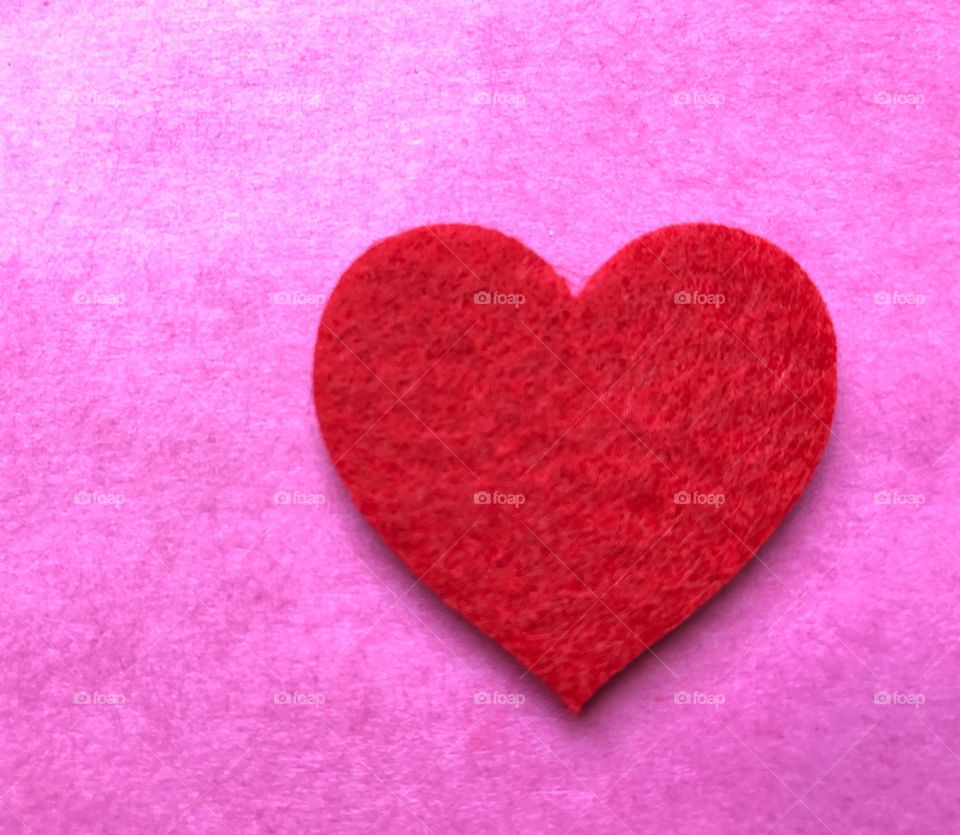 Red felt heart on pink