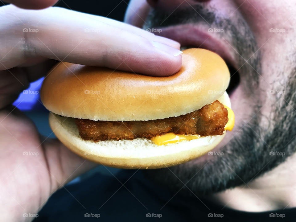 Young man eating a cheeseburger 