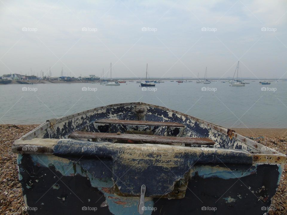 Old saltwater fishing boat, sailboats and sea background, England