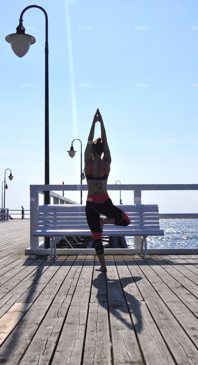 Yoga on the pier at the Baltic Sea coast in Poland 