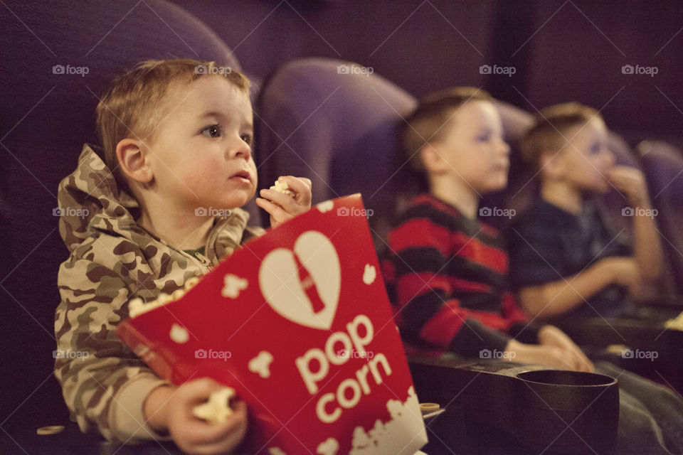 Kids in a movie theater eating popcorn
