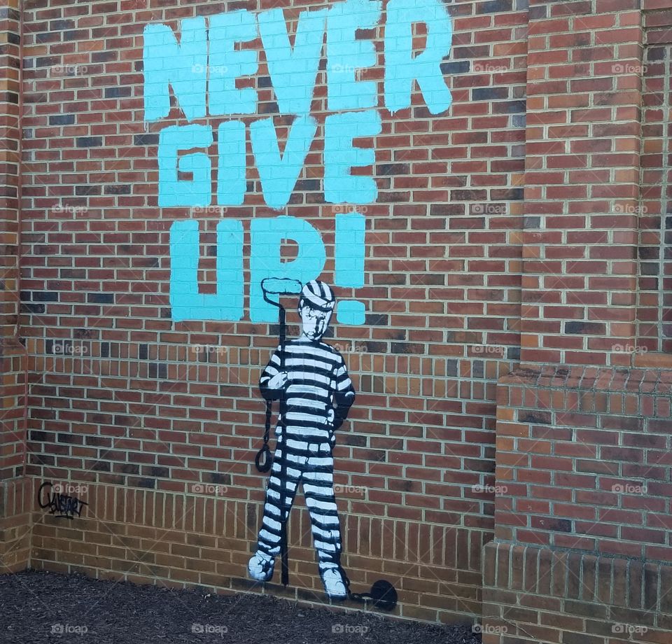Graffiti art with inspirational words on brick building