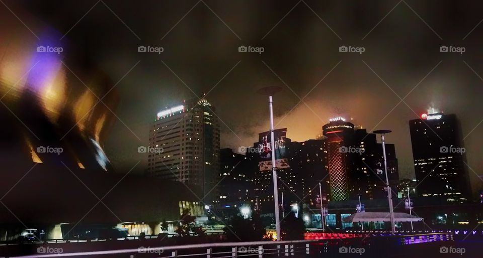 City skyline by night at the Mercedes-Benz Superdome, New Orleans, Louisiana, USA. Image acquired on a rainy and foggy evening.