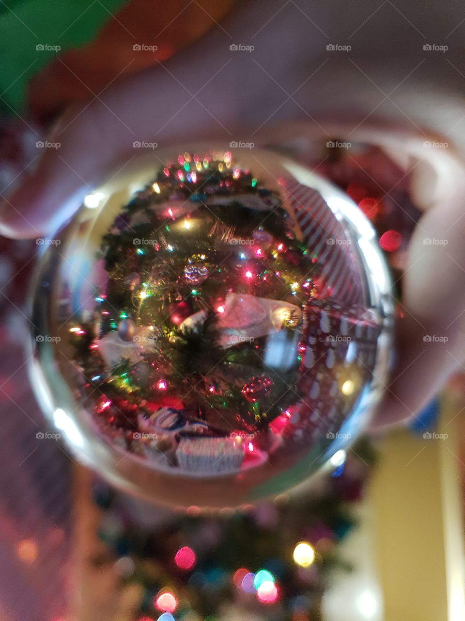 A beautifully decorated Christmas tree through an orb.